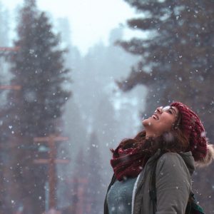 Snow falling woman looking up