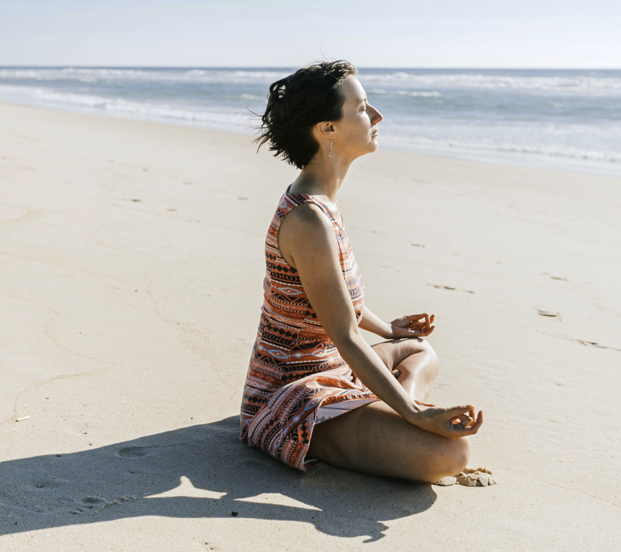 Woman on beach Woman sitting on beach meditating